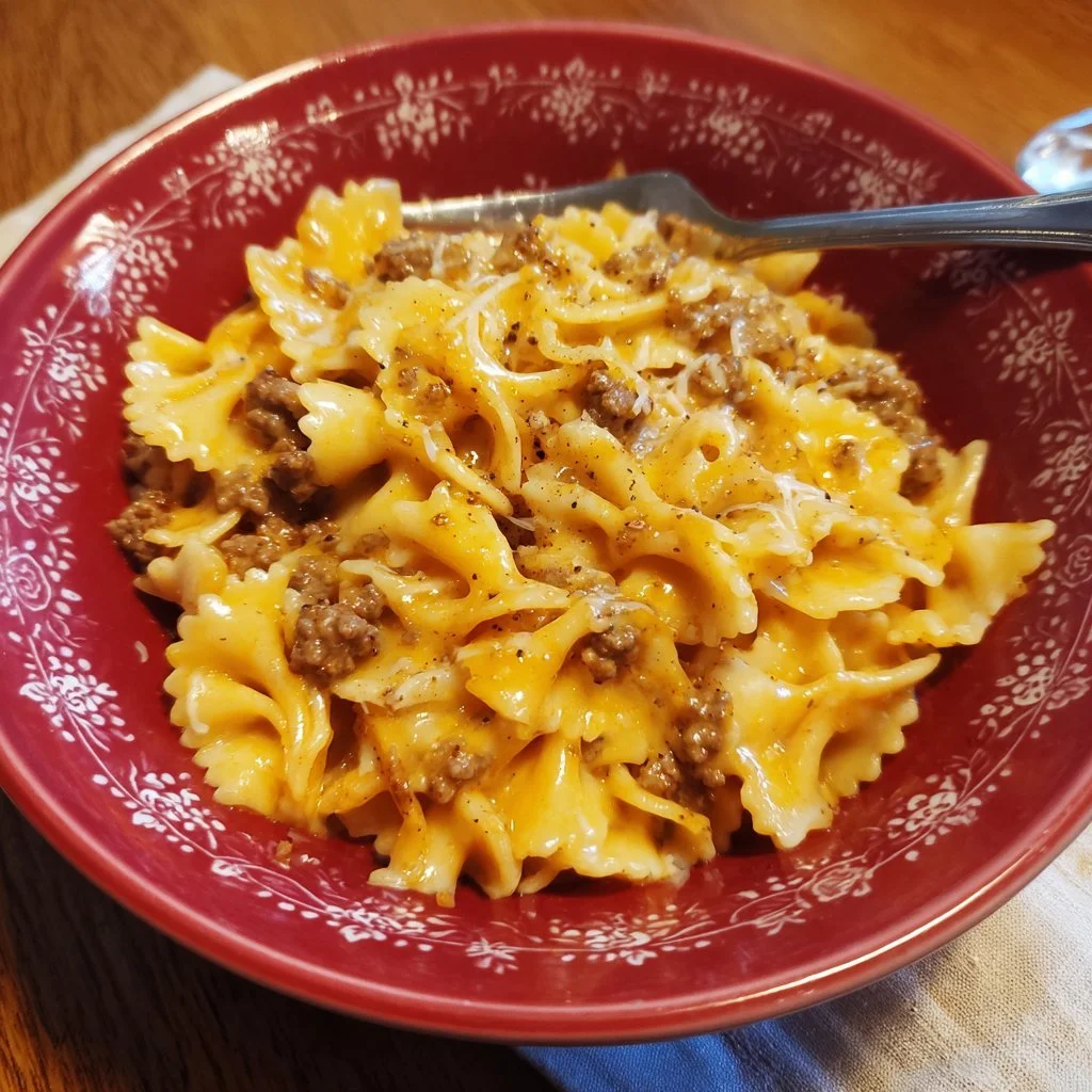 Creamy Rotel pasta with ground beef topped with cheese on a plate