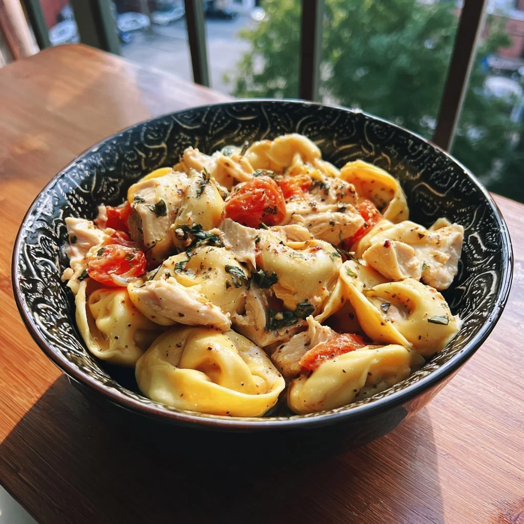 CrockPot Chicken Tortellini dish ready to serve with fresh herbs on top.